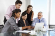 © Monkey Business - Group Of Business People Having Meeting Around Laptop At Glass Table