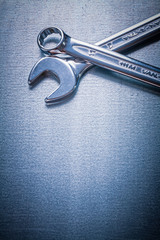 Stainless flat spanner and hook wrench on metallic background co