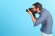 © luismolinero - Young hipster man photographing over white background