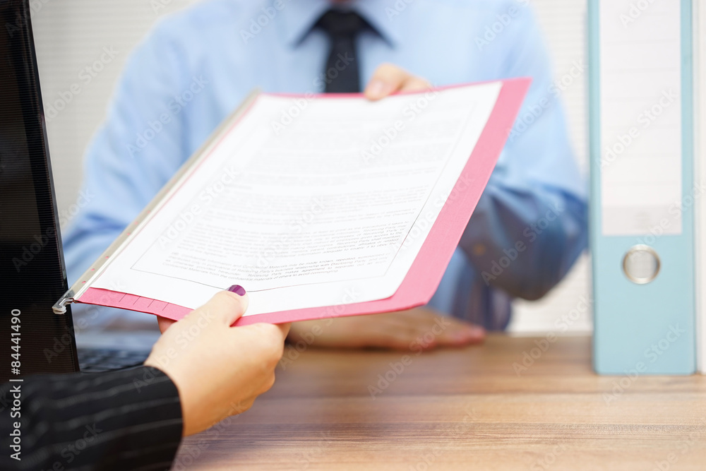 business woman is passing document to manager