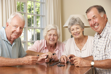 Wall Mural - Group Of Senior Couples Enjoying Game Of Dominoes At Home