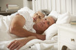 Senior Woman Tries To Be Affectionate Towards Husband In Bed