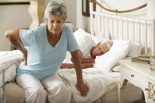 Fotografía Senior Woman Suffering From Backache Getting Out Of Bed