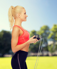 Wall Mural - smiling sporty woman with skipping rope