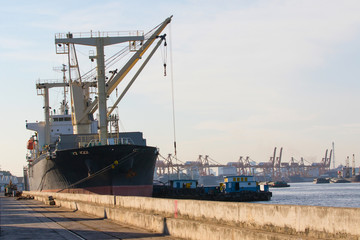  container ship loading material goods from local ship in habor p