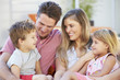 © Monkey Business - Family Sitting  On Garden Seat Together
