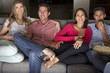 © Monkey Business - Group Of Friends Sitting On Sofa Watching TV Together