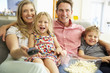 © Monkey Business - Family Relaxing On Sofa Watching Television Together