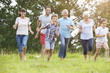 © Monkey Business - Multi Generation Family Running Across Field Together