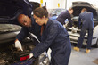 Teacher Helping Student Training To Be Car Mechanics