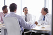 © Monkey Business - Four Businessmen Having Meeting Around Boardroom Table