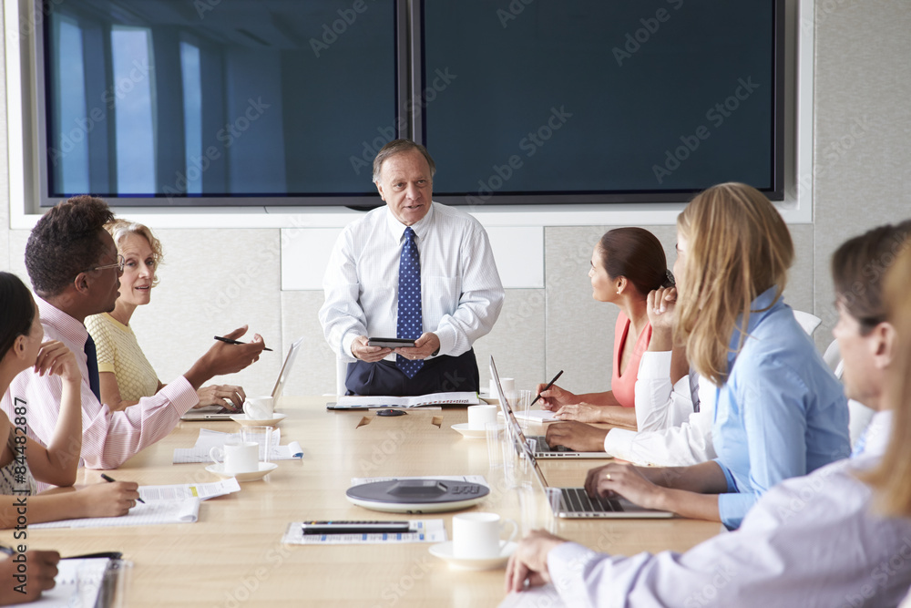 Group Of Businesspeople Meeting Around Boardroom Table - obrazy, fototapety, plakaty 