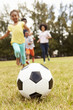 © Monkey Business - Family Playing Soccer In Park Together