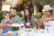 © Monkey Business - Multi Generation Family Eating Meal At Outdoors Together