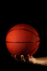 Wall Mural - Basketball player holding ball, on dark background