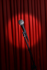 Wall Mural - Microphone on stand on red curtain background