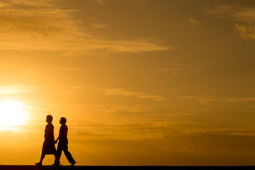 Silhouette people walking at sunset