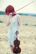 The red-haired girl with a violin outdoor