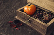 Heart from a stone in a wooden brown casket with dry flowers on a wooden surface