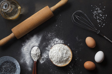 Wall Mural - flour and ingredients on black table