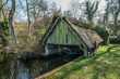 Run down thatched boathouse on Norfolk Broads surrounded by tree