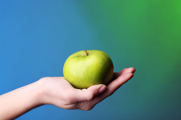Wall Mural - Female hand with apple on colorful background
