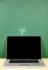 Sticker - Laptop on table, on green blackboard background