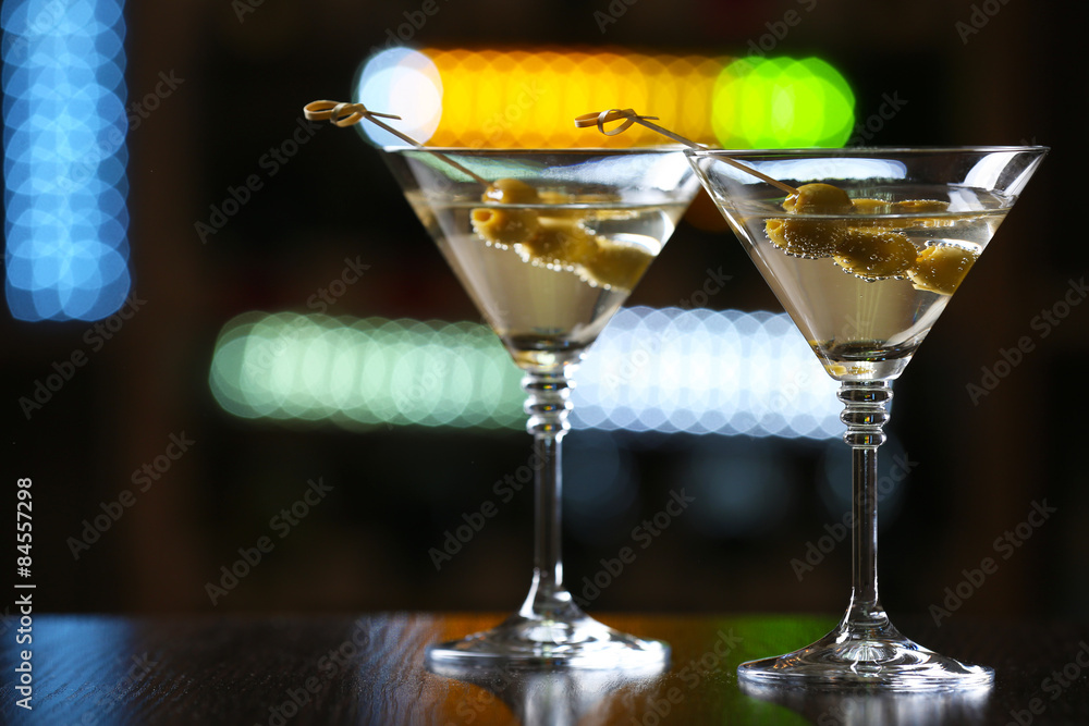 Glasses of cocktails on bar background