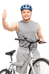 Wall Mural - Biker giving thumb up and posing with a bicycle