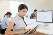 © goodluz - Young business girl working on digital tablet in office