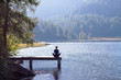© NicoElNino - Woman doing yoga at lake