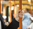 Passenger holding handgrip in tramway