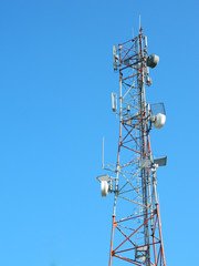 Communication Tower with Parabolic and GSM Antennas on beautiful blue sky