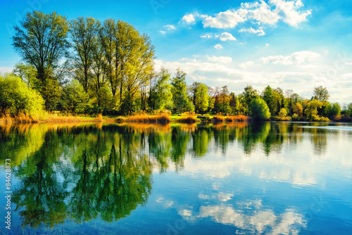 Tranquil lakeshore landscape with blue sky and water