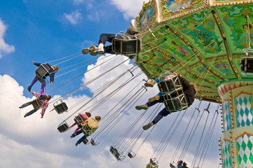 unrecognizable people on flying swing attraction