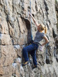 © zhukovvvlad - Young woman with rope climbs on the rock.