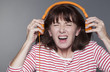 © STUDIO GRAND WEB - mature woman suffering from listening to loud music on headphone