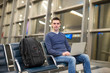 © travnikovstudio - Young man with laptop and backpack at airport
