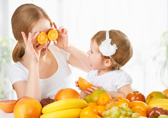 Wall Mural - happy family mother and daughter little girl, eat healthy vegeta