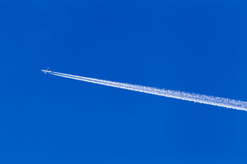 A long trail of jet plane on blue sky