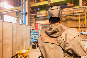 Wall Mural - Young man in a welding factory in protective workwear