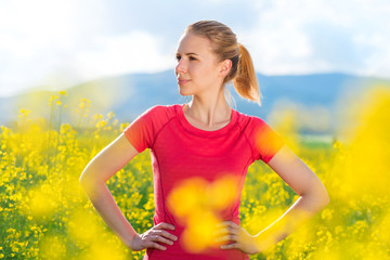 Wall Mural - Beautiful young girl running in a canola field