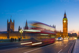 Fototapeta Londyn - London, United Kingdom - Iconic Double Decker bus on the move on Westminster bridge with illuminated Big Ben clock tower and Parliament at background at blue hour