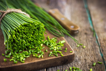 bunch of  chives on a wooden cutting board