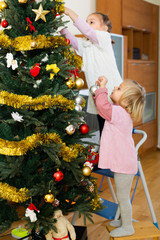 Wall Mural - Little girls decorating Christmas tree