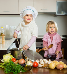 Wall Mural - Two little sisters learning how to cook