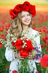 Blonde girl in poppy field on sunset. Soft focus.
