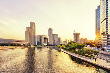 Wall Mural - modern skyscrapers and skyline during sunset at riverbank