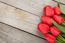 Fresh Red Tulips Bouquet Over Wooden Table Background