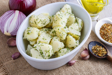 Wall Mural - Bowl of boiled potatoes, fresh vegetables and herbs around